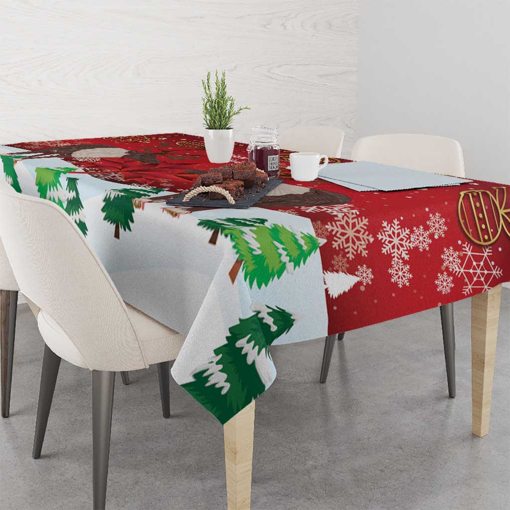 Red tablecloth corner detail with green pine trees and caribou print.