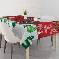 Red tablecloth corner detail with green pine trees and caribou print.