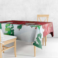 Red tablecloth draped over table with green pine tree and maple leaf motifs.