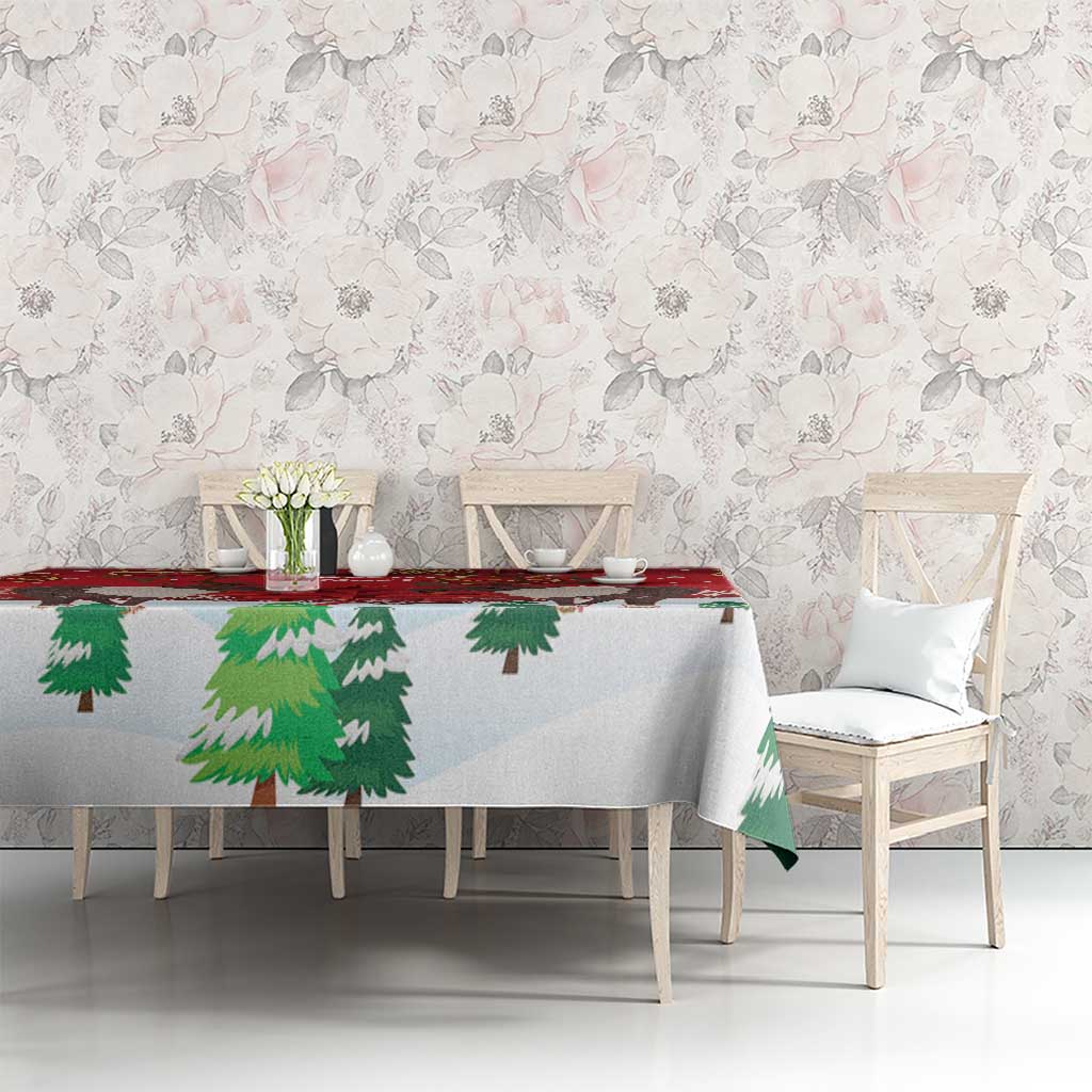 Red Christmas tablecloth on dining table with caribou and green pine tree motifs.