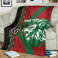 Custom rugby blanket on couch with red-green diagonal, lion face, and “YOUR TEXT”