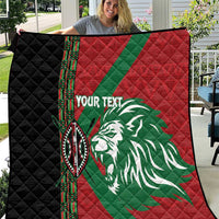 Red, green and black quilt with lion graphic, patterned border, and diamond quilting