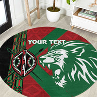 Round red, green and black rug with lion head and patterned tribal emblem design