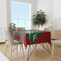 Red and green tablecloth with lion graphic and African pattern border, draped over table