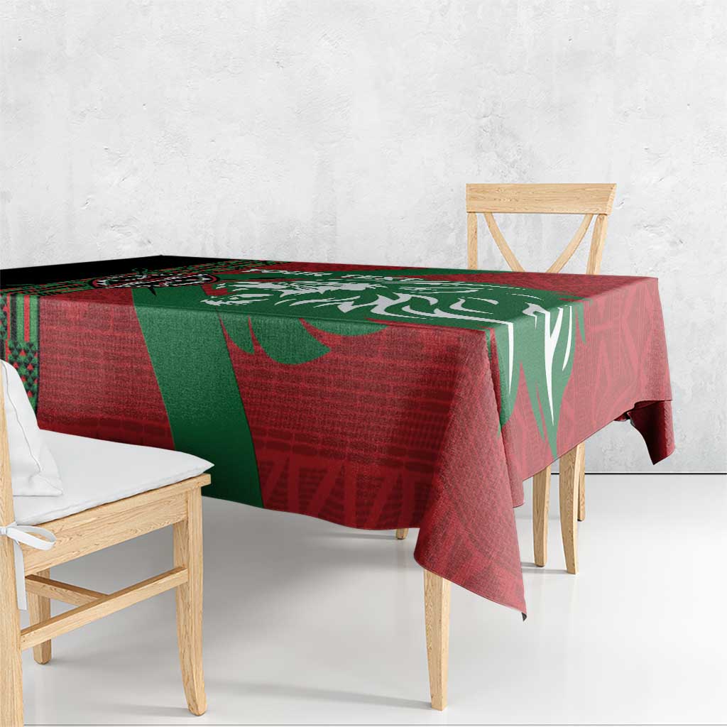 Red and green tablecloth with geometric border and lion illustration, draped on table