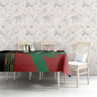 Red and green lion and geometric pattern tablecloth on long dining table with chairs