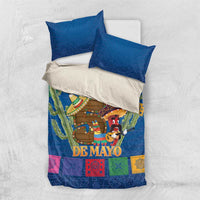 Blue bedding set with two pillows and 'DE MAYO' center print, cacti and sombrero characters