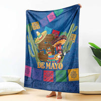 Blue blanket draped over couch with colorful border tiles, cactus, and 'DE MAYO' center