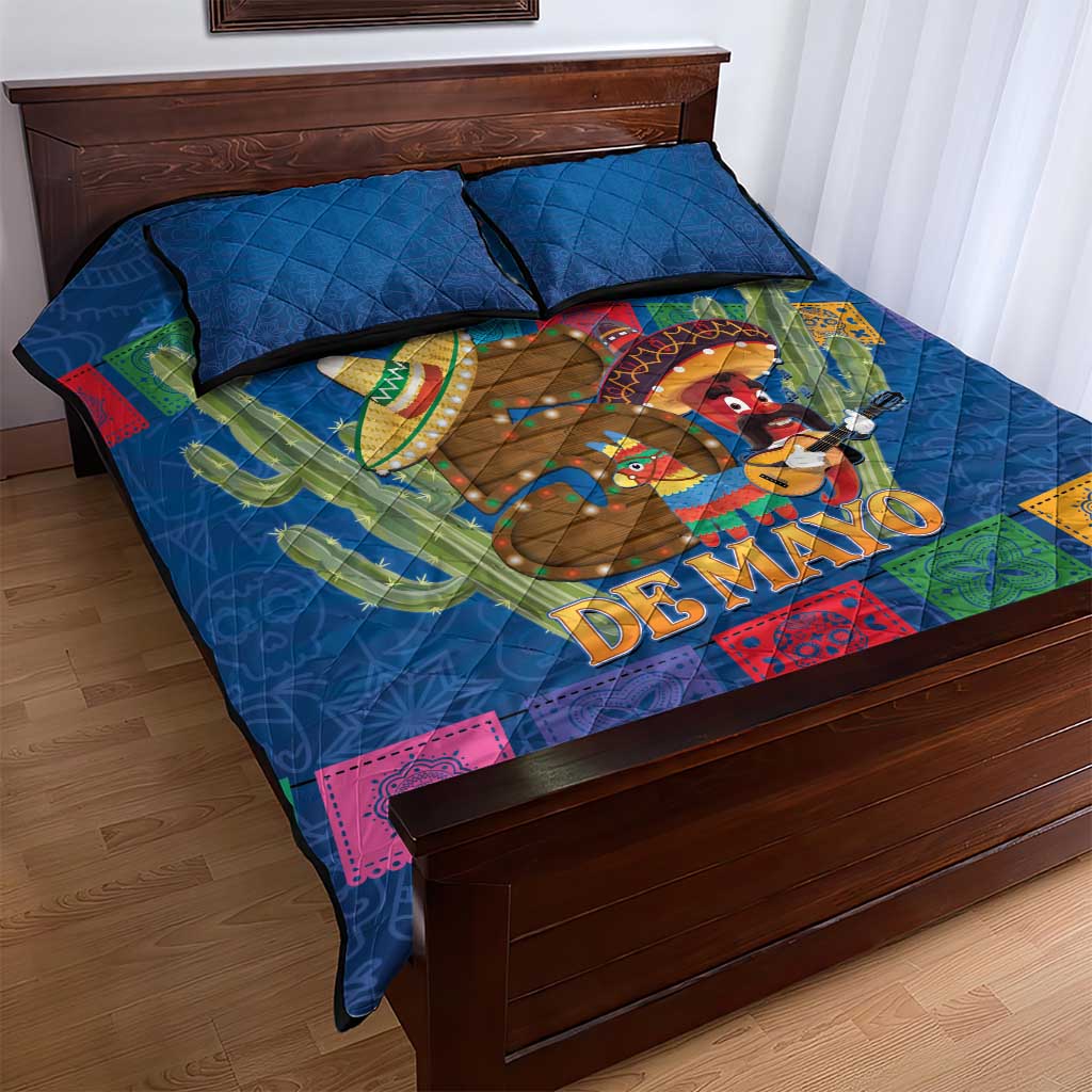 Blue quilt bed set with cowboy and cactus 'DE MAYO' artwork, quilt and two pillows on frame