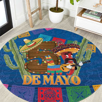 Round blue carpet with large "DE MAYO" text, mariachi figures, and colorful border designs