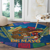 Round blue carpet close-up with "DE MAYO" text and mariachi sombrero figures in center