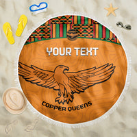 Orange round beach blanket with fringe, Kente band and eagle emblem with text