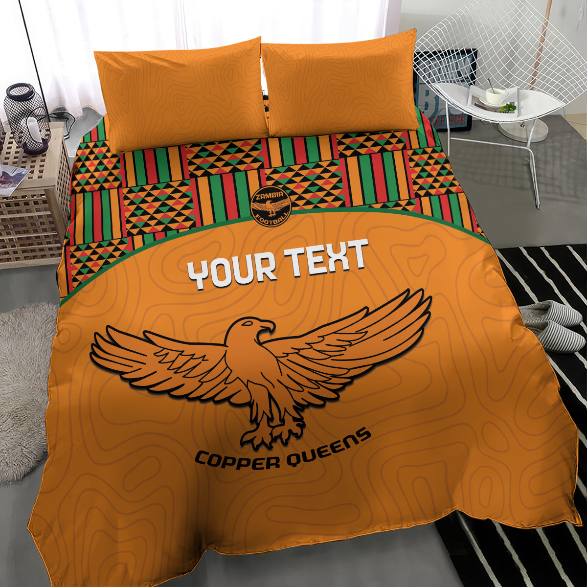 Orange bedding set with two pillows, Kente-striped bands, and bold bird emblem design