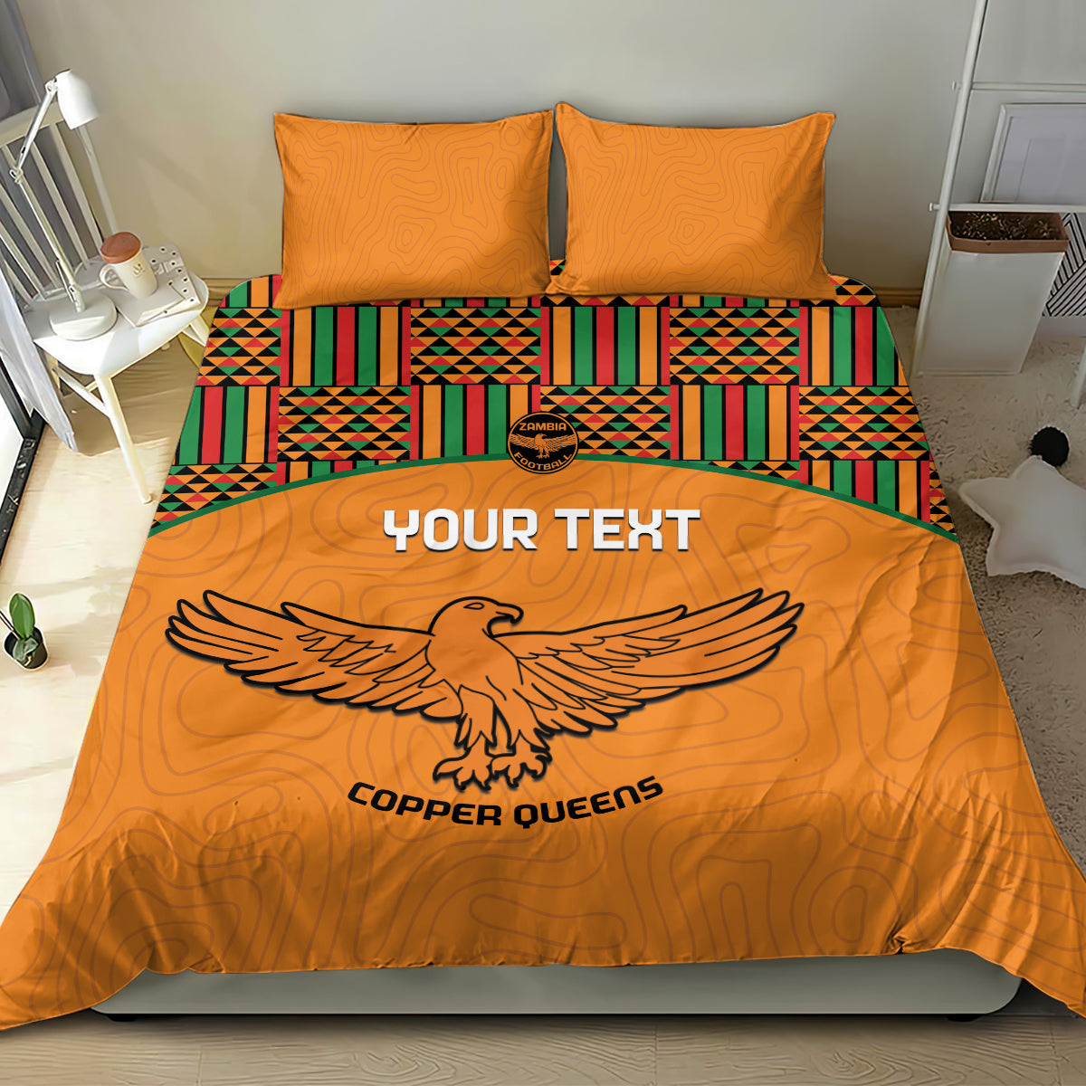 Orange duvet and two pillows featuring Kente border stripes and bird emblem artwork