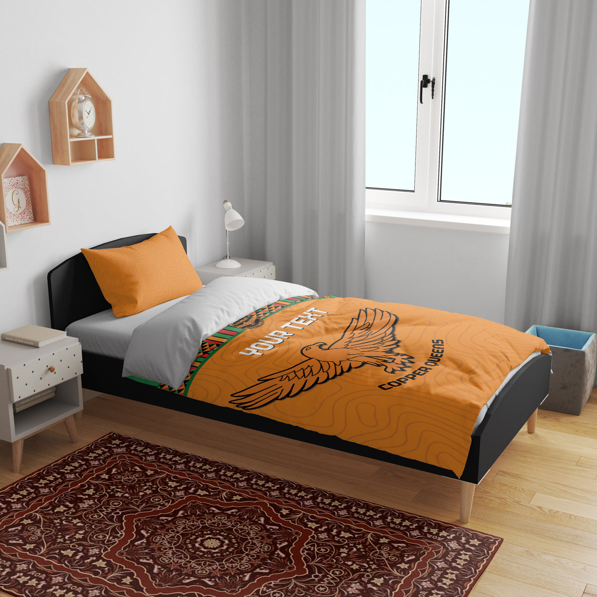 Orange duvet and two pillows with Kente stripes and bird emblem print across the center