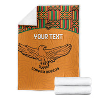 Orange football blanket folded with Kente trim and eagle graphic, plus included white towels
