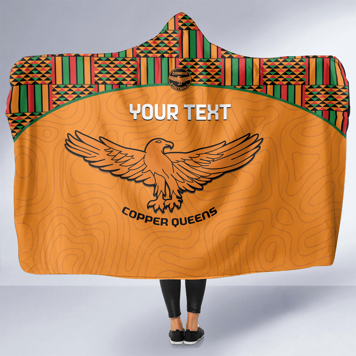 Orange hooded football blanket with Kente hood, “YOUR TEXT”, and Copper Queens eagle logo