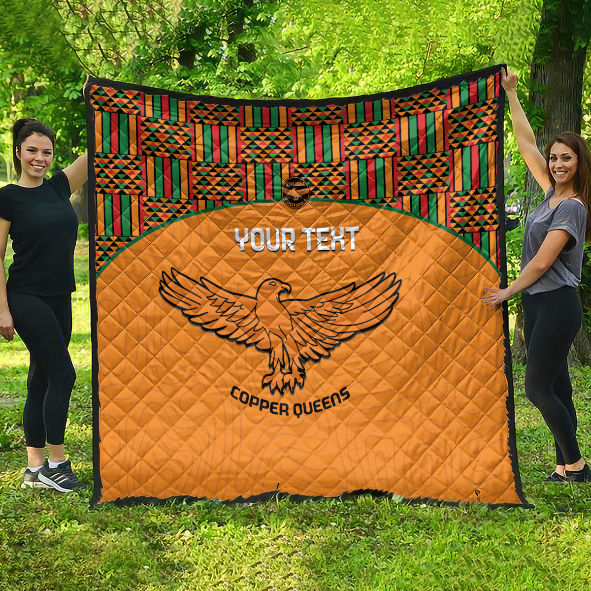 Orange football-style quilt with green, red, and yellow Kente border and eagle logo