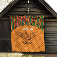Orange quilted throw with multicolor Kente border and centered eagle Copper Queens logo
