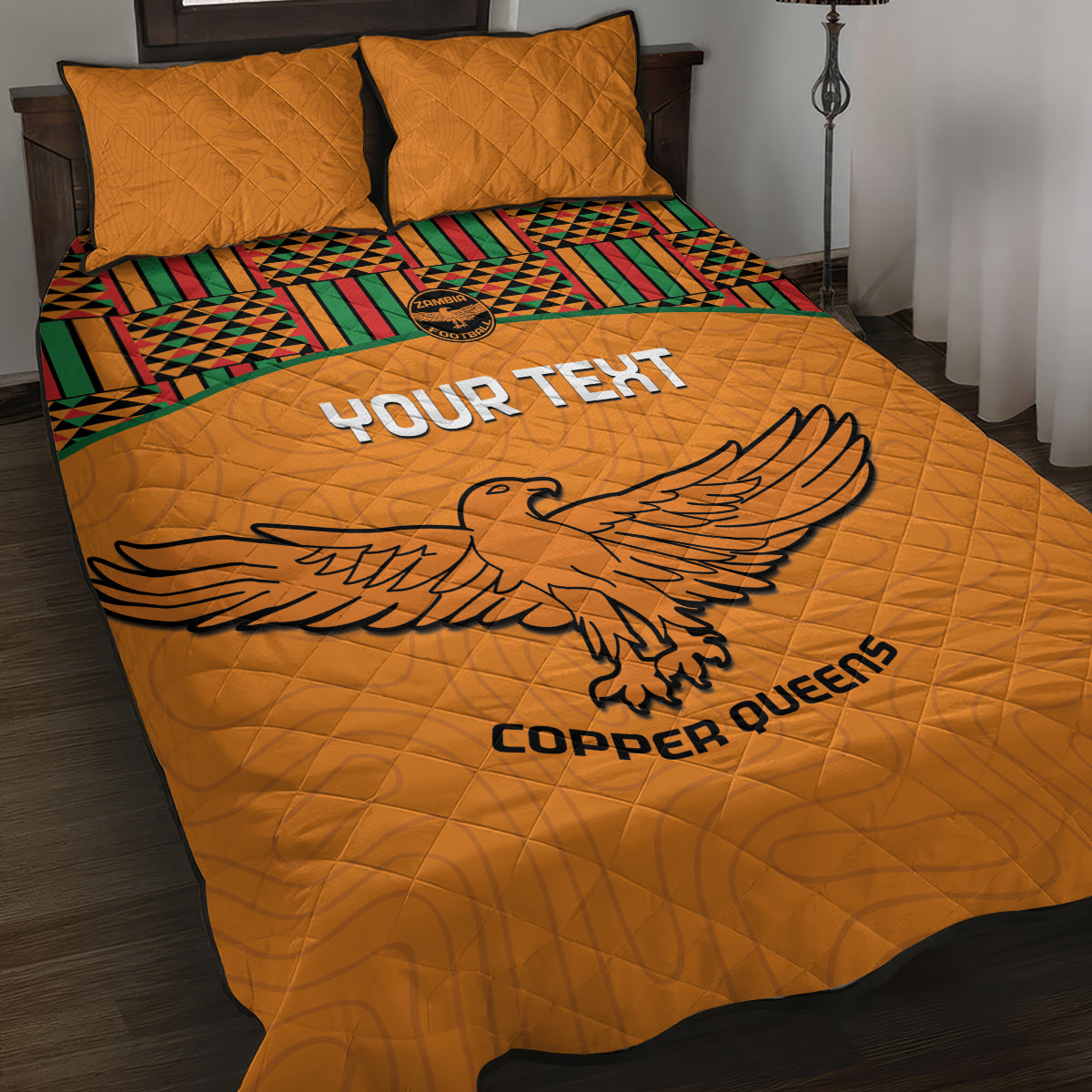 Orange football quilt bed set with eagle graphic, Kente-style stripe border, matching pillows