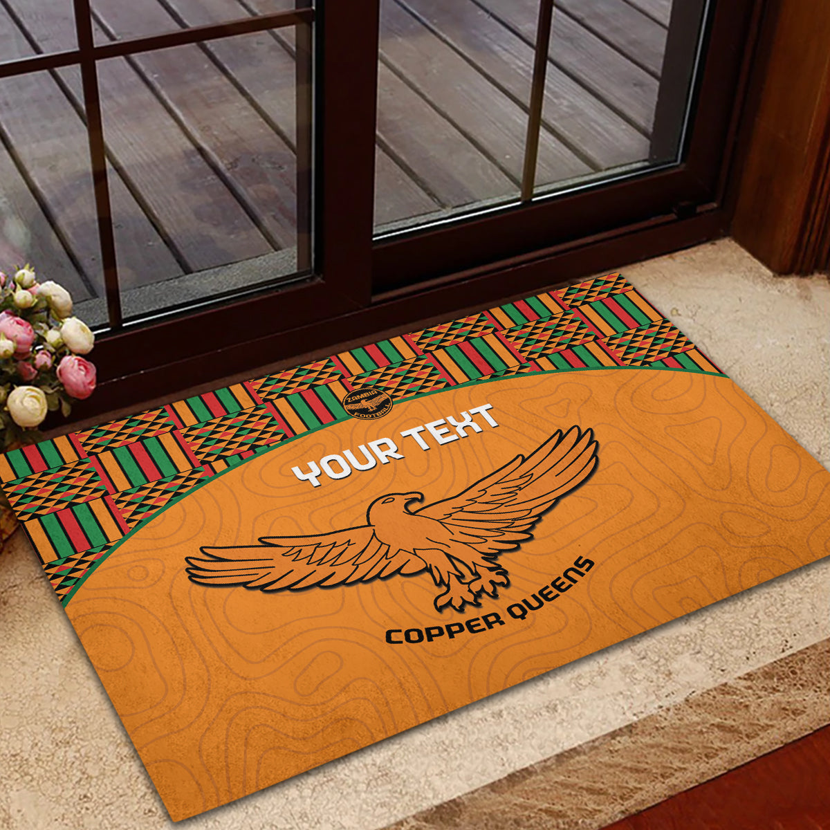 Orange rubber doormat with kente trim and eagle graphic at the doorway