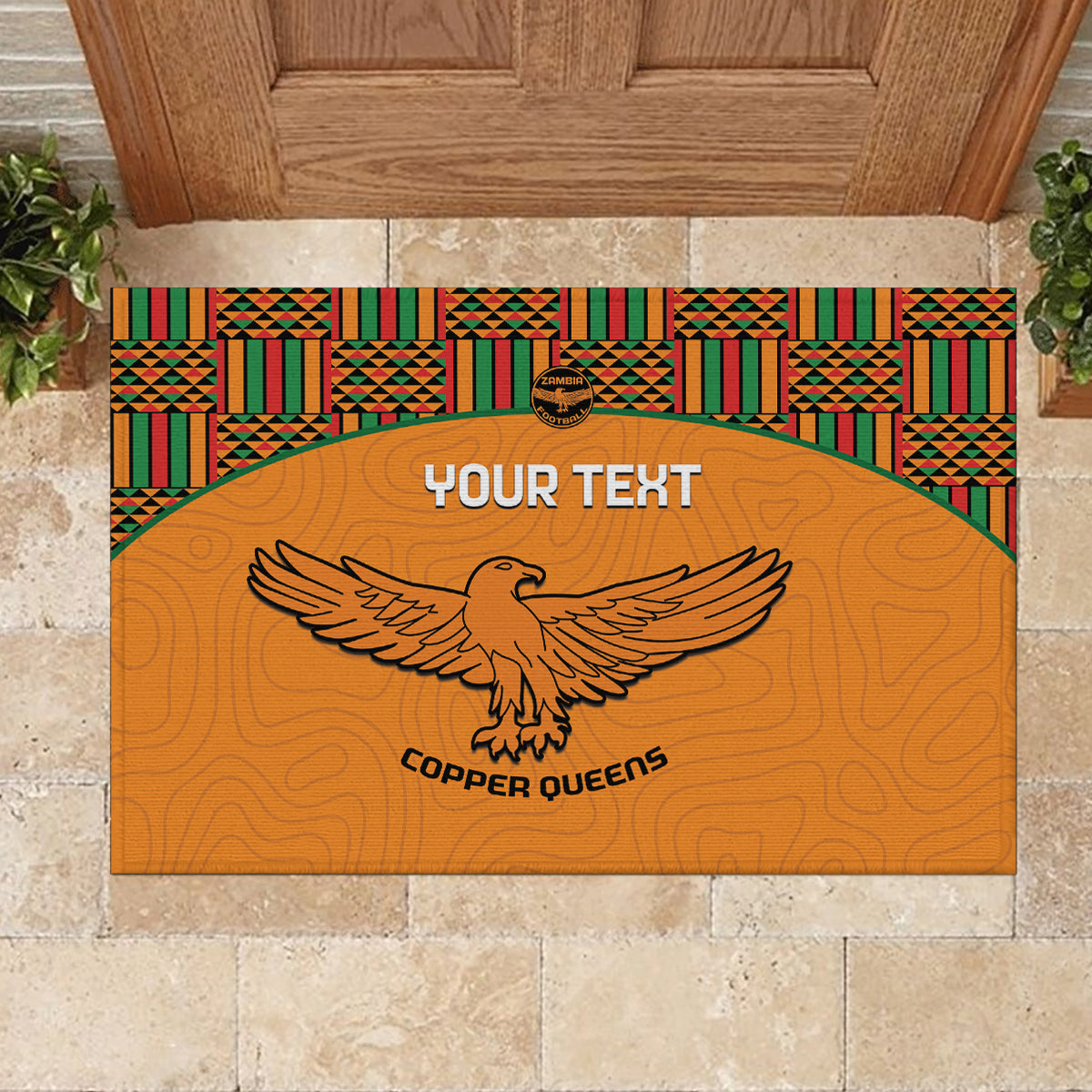 Orange rubber doormat with kente border, large eagle logo, and “YOUR TEXT”