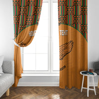 Orange window curtains with kente-pattern top and winged bird design on the panel
