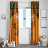 Pair of orange window curtains with kente top trim and winged bird emblem