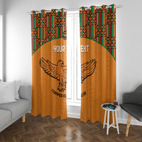 Orange window curtains with kente trim and winged bird graphic over the panels