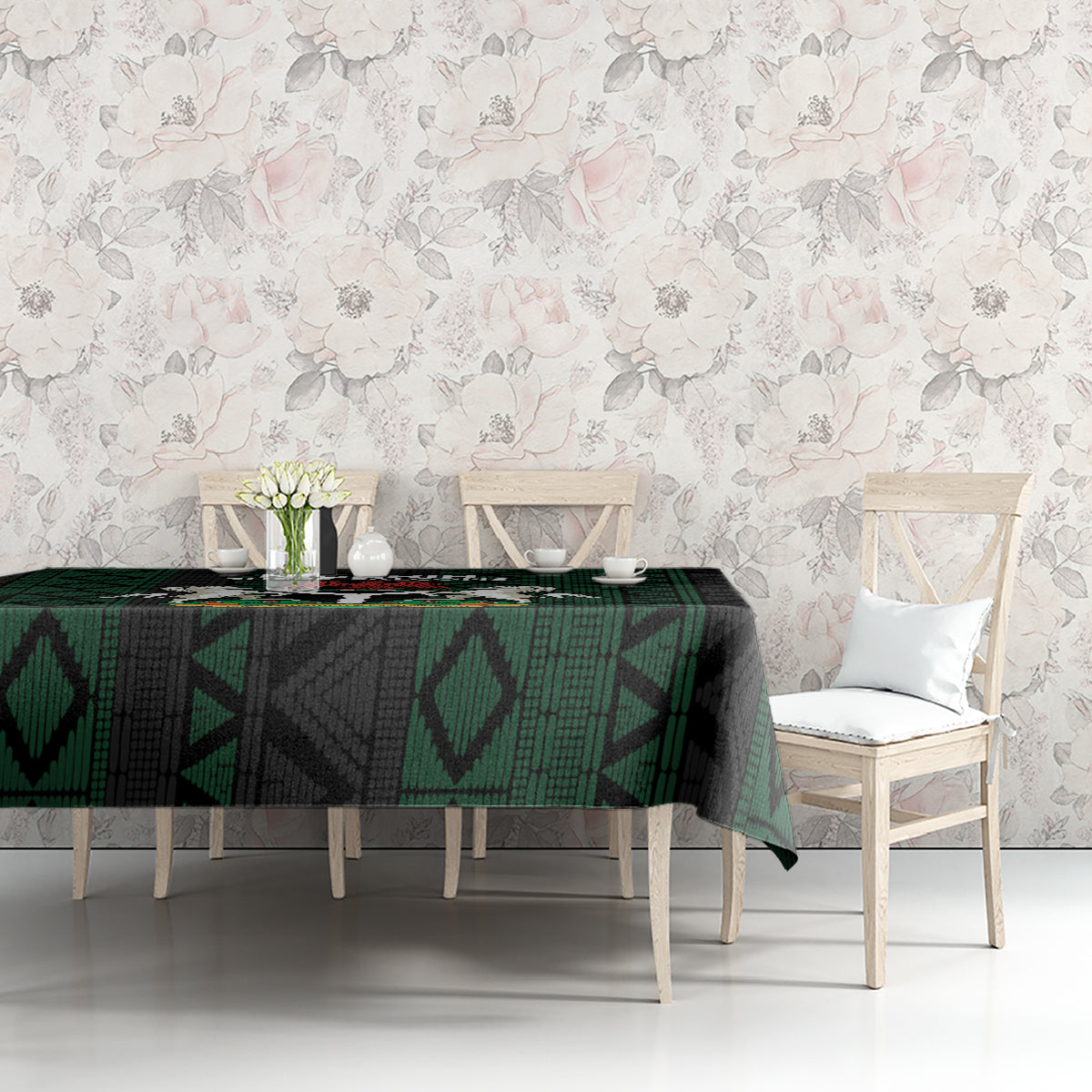 Green and black African pattern tablecloth on table with two white dining chairs