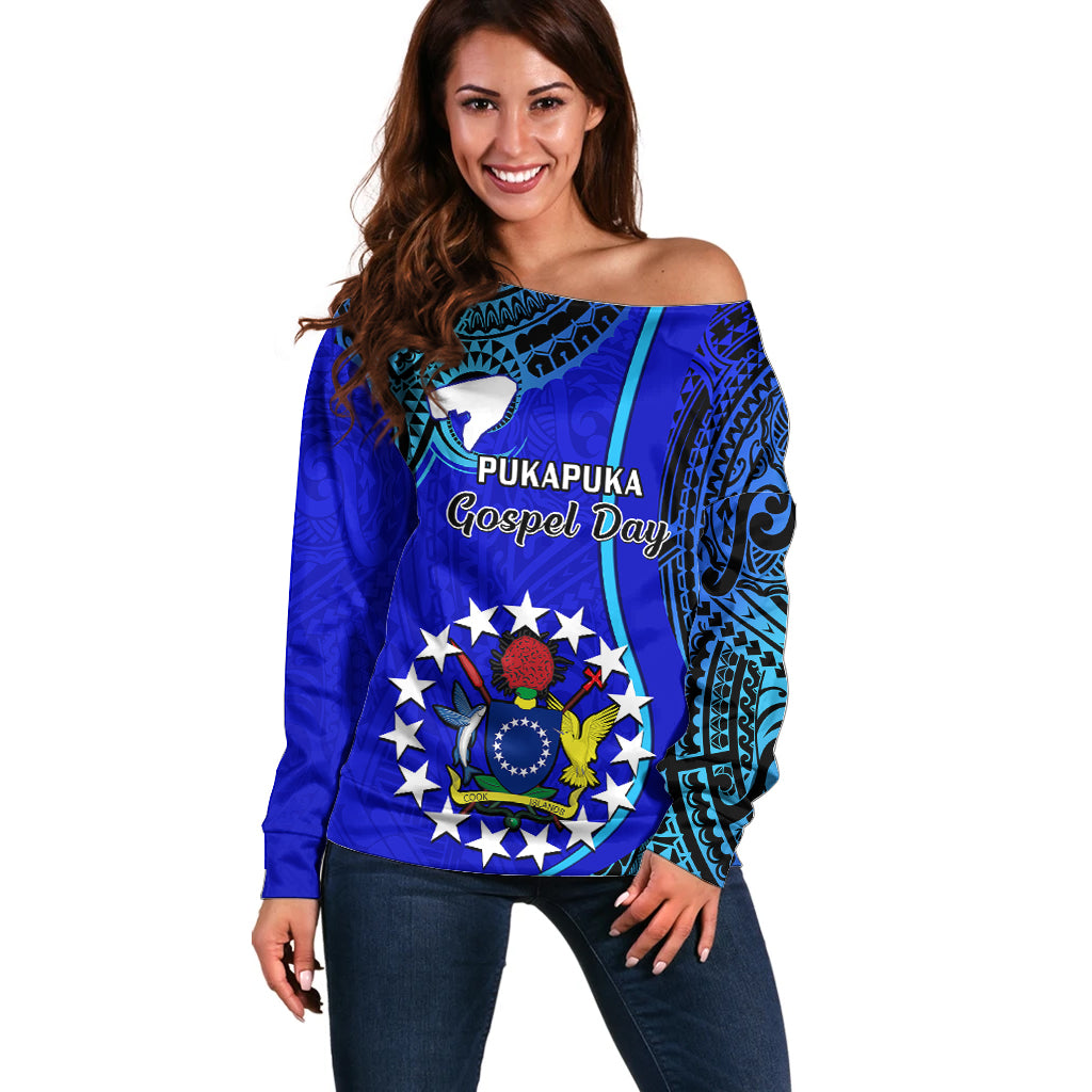 Blue off-shoulder sweater with teal tribal print and circular emblem
