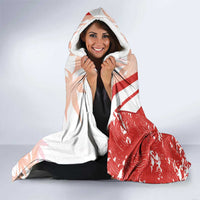 Hooded Canada soccer blanket, red and white with Canada shield graphic, worn over shoulders.