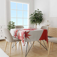 Red and white maple leaf tablecloth draped over dining table, soccer-themed print