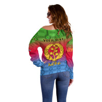Off-shoulder gradient sweater back with kente pattern, 'YOUR TEXT' and gold crest emblem