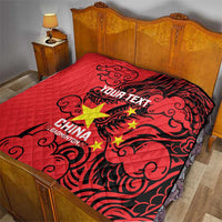 Red quilt on a bed with quilted texture, black dragon design, and yellow star graphics.
