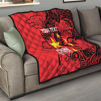 Red quilt draped on a sofa with quilted diamond stitching, black dragon pattern, yellow stars.
