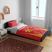 Red bedding set with China stars, yellow stripes, and a white text band centered on duvet.