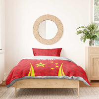 Red duvet with China star emblem, yellow stripes, and gray trim edging; two red pillows.