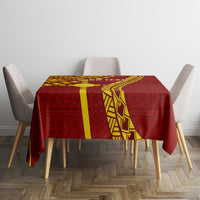 Maroon tablecloth with yellow geometric tapa design and center stripe on dining table