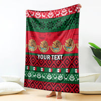 Red Christmas blanket with green bands, festive patterns, medallions, and custom text