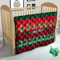 Red and green Christmas quilt for crib with "YOUR TEXT" panel in the center.