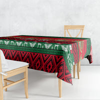 Red and green patterned Mexican Christmas tablecloth draped over dining table