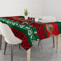 Red, green, and black Mexican Christmas tablecloth on dining table with chairs