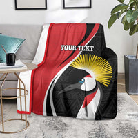 Red and black custom blanket draped over couch, featuring white head graphic and yellow sunburst