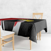 Tablecloth draped over rectangular table: black geometric pattern with white stripe