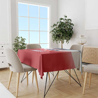 Red tablecloth on a dining table with chairs and a simple smooth drape