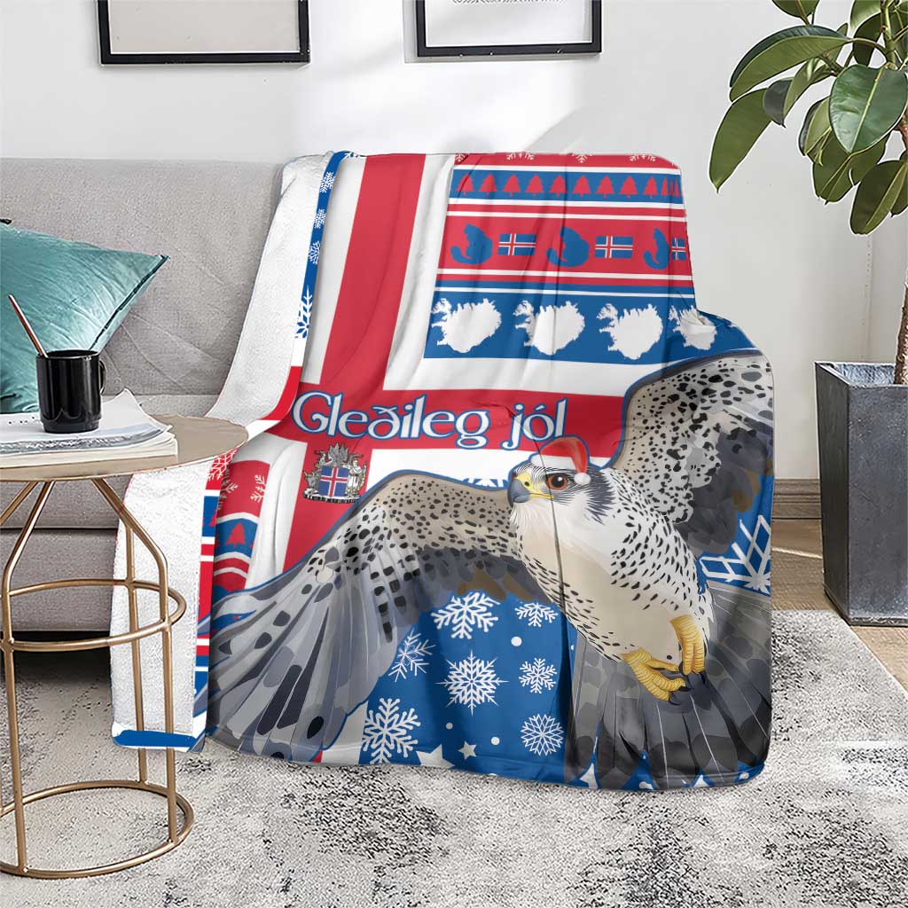 Blue and red Christmas blanket with gyrfalcon, snowflake motifs, and white Nordic lettering