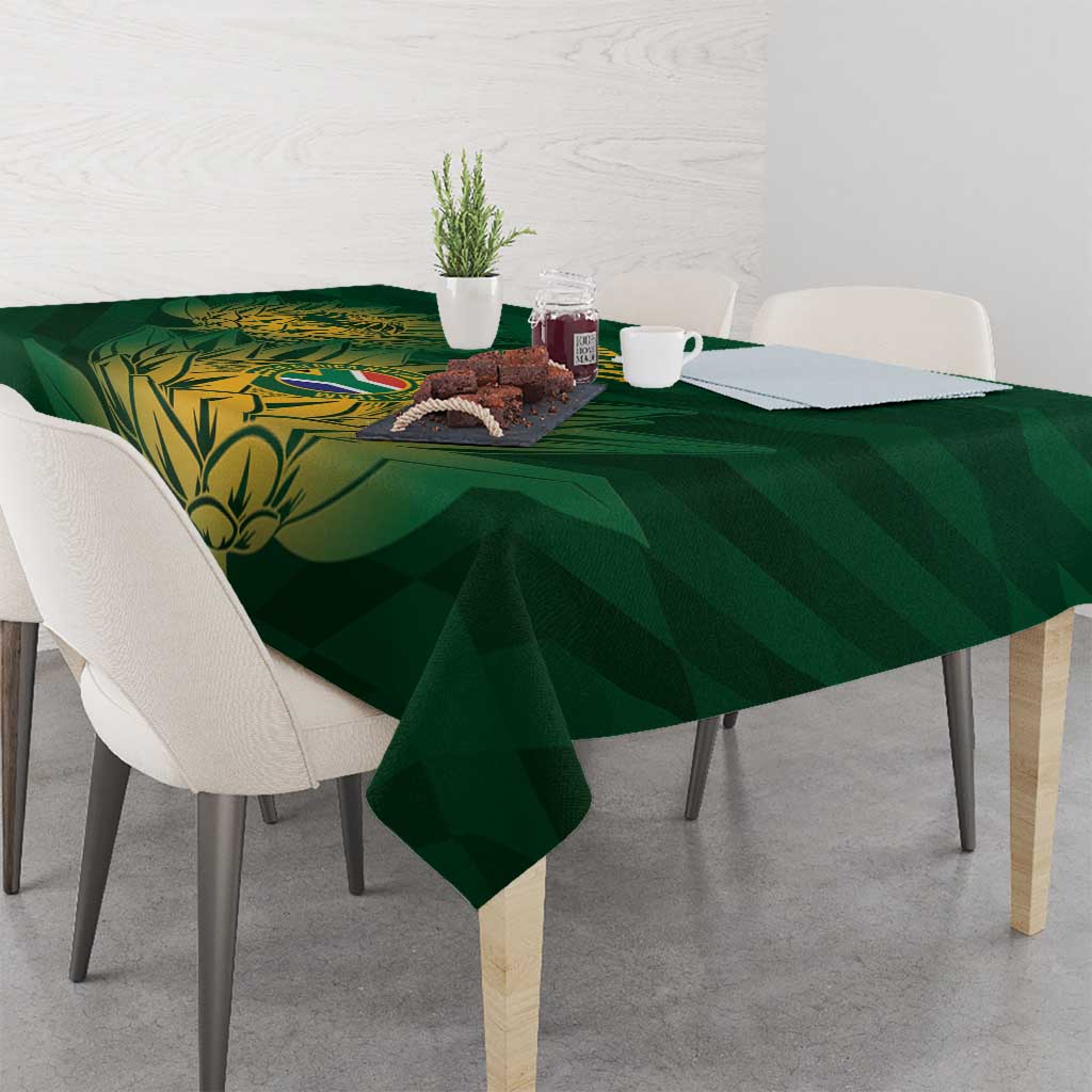 Green tablecloth with gold crest and diagonal foliage design draped over table corners.