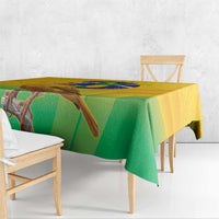 Yellow and green printed volleyball tablecloth with bird-and-globe design, edge overhang.