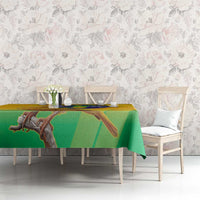 Yellow and green printed volleyball tablecloth with bird and globe motif across tabletop.